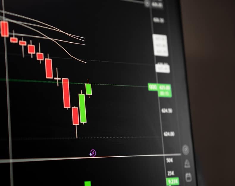 Candlestick stock chart on a dark screen showing red and green candles with grid lines and a price axis to the right, suggesting market activity.